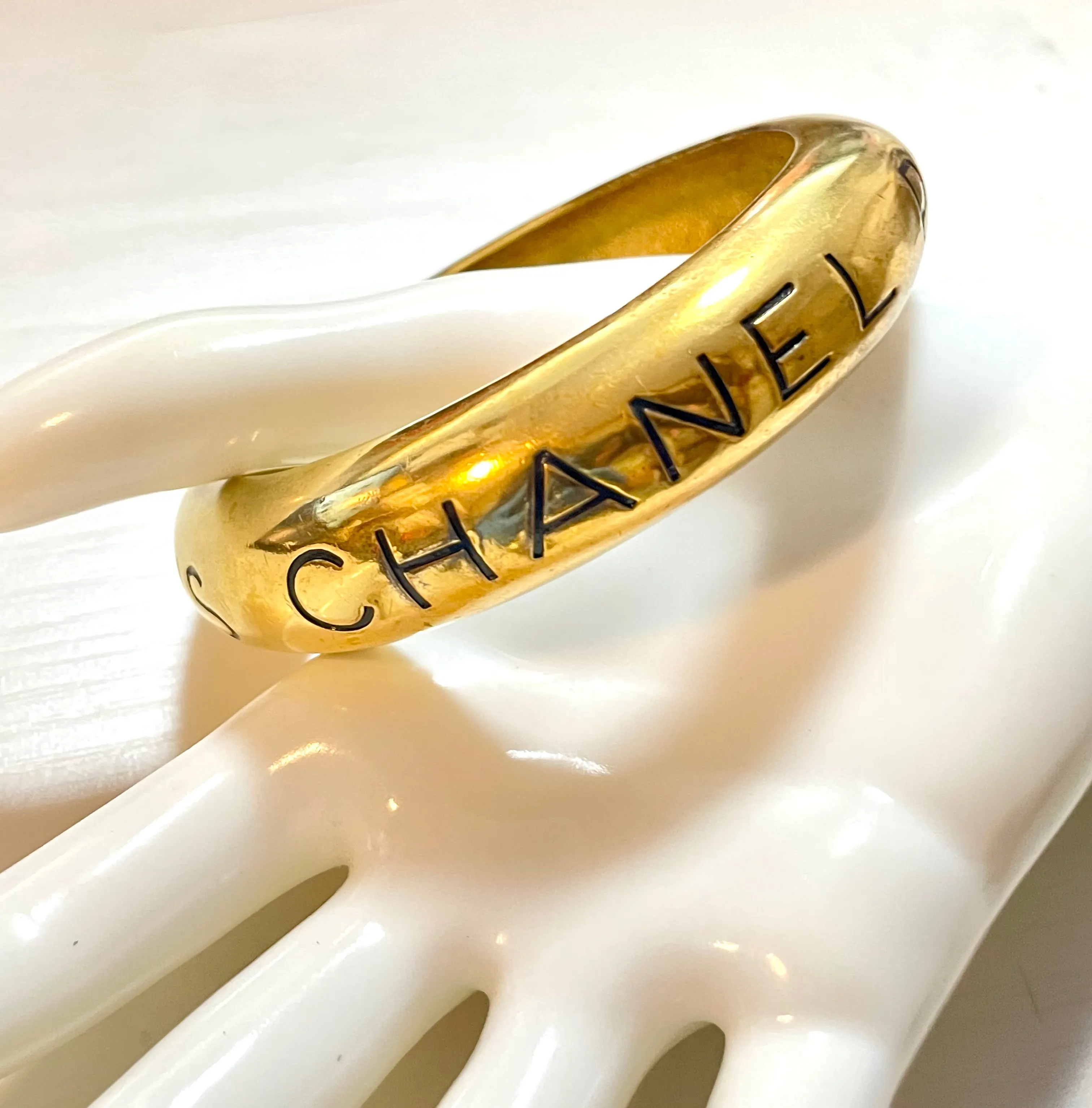 Vintage Chanel golden bangle with embossed black logo.  Must have gorgeous jewelry. 060810r1