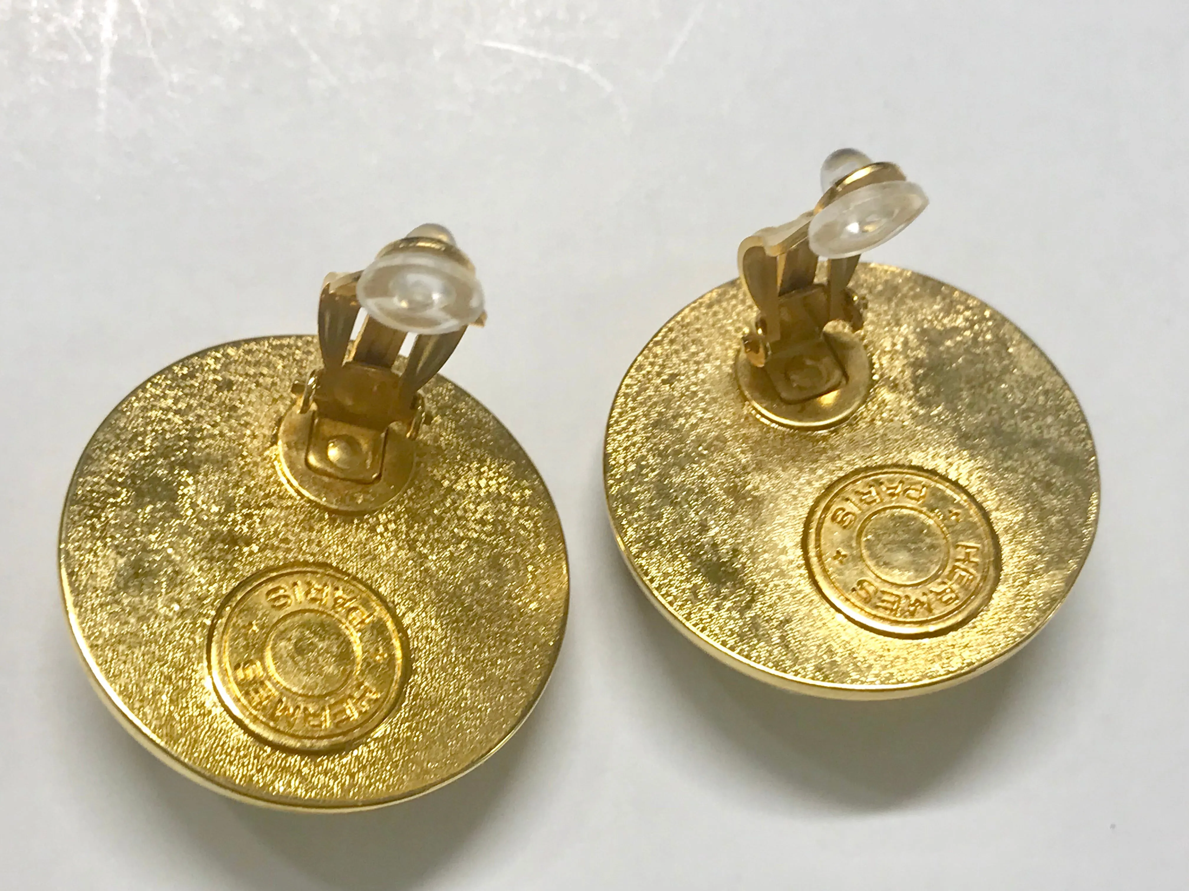 Vintage HERMES golden round earrings with white silk fabric frames. Classic jewel piece.